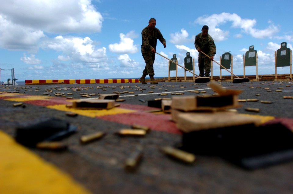 US Navy 050623-N-9866B-037 Two Marines, assigned to the 3rd Amphibious Assault Battalion based at Camp Pendleton, Calif., sweep up spent shell casings