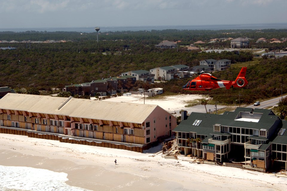 US Navy 050711-C-0000B-001 A U.S. Coast Guard HH-65 Dolphin helicopter, assigned to Air Station New Orleans, conducts an assessment of damage caused by Hurricane Dennis photo