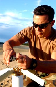 US Navy 050624-F-5820C-002 Officer in Charge Explosive Ordnance Disposal Mobile Unit Five (EODMU-5), Lt. Chris Brown, connects rocket engines in series for disposal during operation Exercise Talisman Sabre 2005 photo