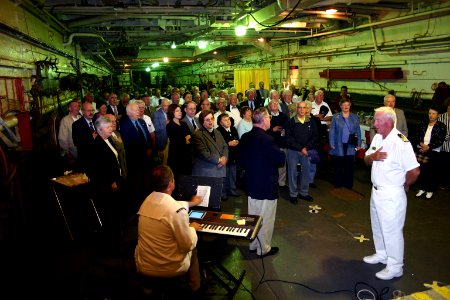 US Navy 050617-N-8110K-127 Musician 2nd Class Brian Hendrix of Navy Band Northeast, seated at keyboard, plays the National Anthem on the well deck of LST 325 during a reception for the LST Memorial Crew and their Captain