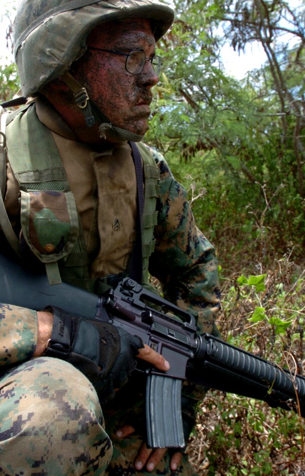 US Navy 050627-N-9866B-043 U.S. Marine Corps Cpl. Jason Dobos waits on the side of the road for his simulated enemy