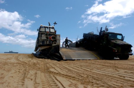 US Navy 050628-N-9866B-006 Sailors assigned to Assault Craft Unit Five (ACU-5) watch as a truck, filled with distilled water, drives off their Landing Craft, Air Cushion (LCAC)