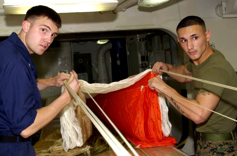 US Navy 050705-N-0361G-031 U.S. Marine Corps Sgt. Juan Franco, right, and Aircrew Survival Equipmentman 3rd Class Brian Hansen perform a canopy inspection on an A-P22P-11 parachute aboard the nuclear-powered aircraft carrier US