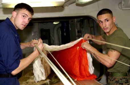 US Navy 050705-N-0361G-031 U.S. Marine Corps Sgt. Juan Franco, right, and Aircrew Survival Equipmentman 3rd Class Brian Hansen perform a canopy inspection on an A-P22P-11 parachute aboard the nuclear-powered aircraft carrier US