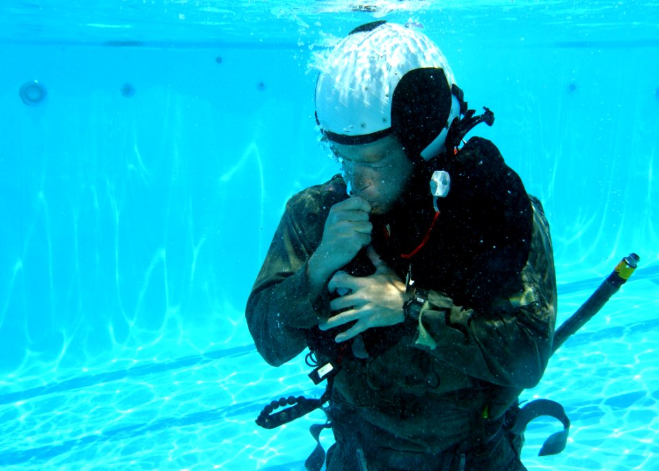 US Navy 050623-N-9500T-086 A student attending the refresher course in water survival at Aviation Survival Training Center, Marine Corps Air Station Miramar, orally inflates his survival vest