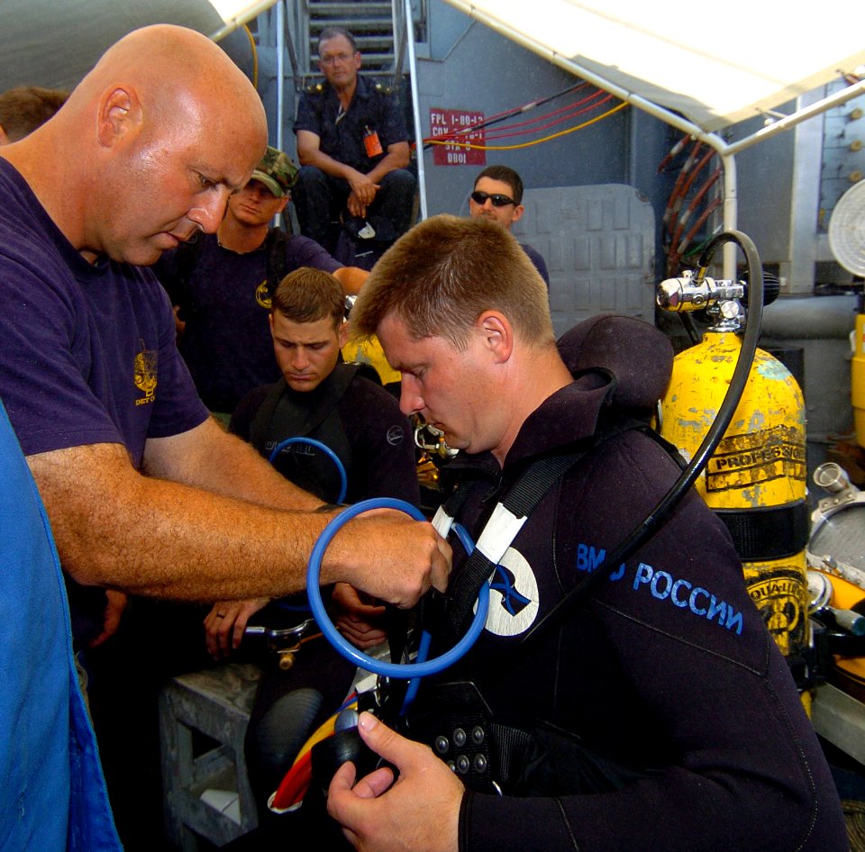 US Navy 050624-N-8861F-001 U.S. Navy Diver Chief Electrician's Mate Mike Welsh helps Russian Navy Diver Igor Zhiazhivov check his gear before the dive aboard the salvage ship USS Grasp (ARS 51)