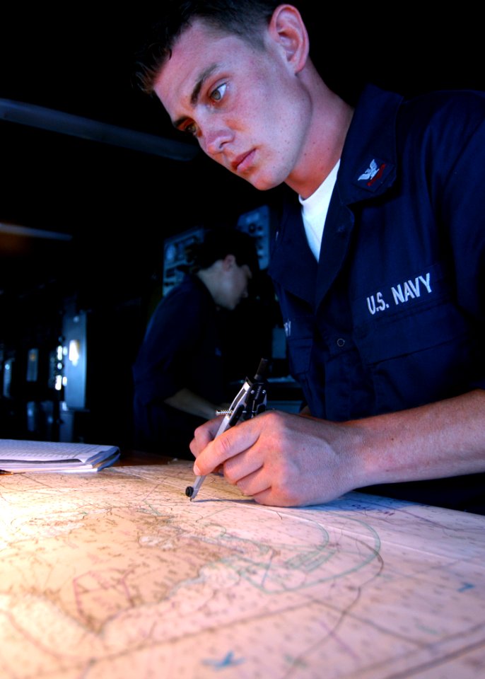 US Navy 050722-N-3019M-007 Quartermaster 2nd Class David Barry plots the ship's course aboard the dock landing ship USS Pearl Harbor (LSD 52)