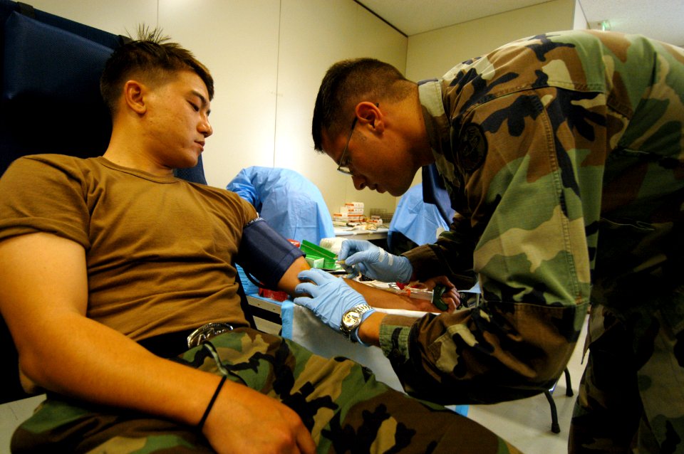 US Navy 050712-N-2385R-014 U.S. Army Spc. John Reed, a member of the Armed Services Blood Program, draws blood from a U.S. Navy blood donor
