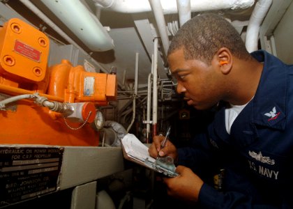 US Navy 050713-N-4374S-002 Gas Turbine System Technician 3rd Class Travis Buchanon logs a reading from a hydraulic oil power module for a control reversible pitch propeller in Main Engine Room Two