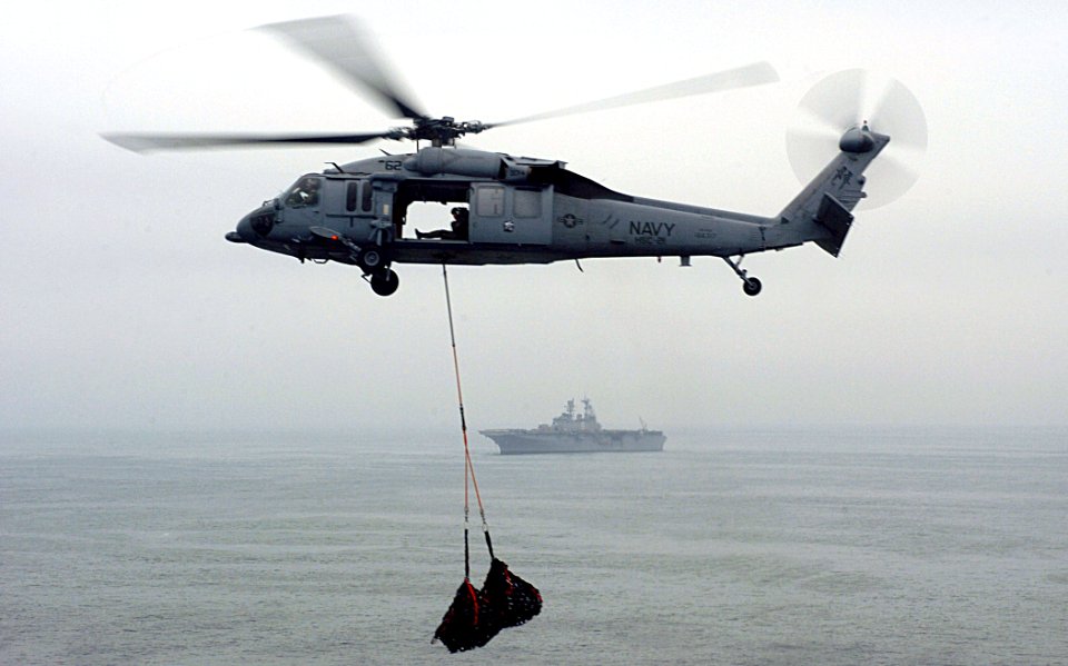 US Navy 050719-N-9866B-008 An MH-60S Seahawk helicopter, assigned to the Blackjacks of the Helicopter Sea Combat Squadron Two One (HSC-21), starts a turn towards SS Bonhomme Richard (LHD 6) during an ammunition on load
