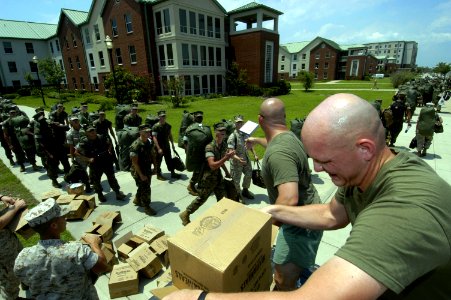 US Navy 050708-N-5328N-960 U.S. Marine Corps Staff Sgt. Chad Roach, foreground, and Gunnery Sgt. Ricdh Renner give pre-packaged meals to Marine students as they leave their barracks and line up to evacuate Naval Air Station (NA
