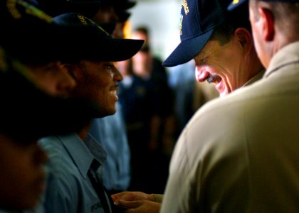 US Navy 050712-N-0962S-074 Master Chief Petty Officer of the Navy (MCPON) Terry Scott pins an Enlisted Aviation Warfare Specialist (EAWS) pin on a Sailor