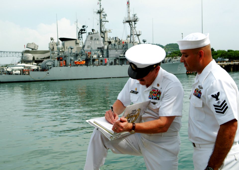 US Navy 050805-N-0962S-188 Master Chief Petty Officer of the Navy Terry Scott signs a charge-book for a chief petty officer selectee assigned to USS Devastator (MCM 6)