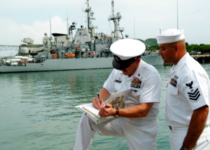 US Navy 050805-N-0962S-188 Master Chief Petty Officer of the Navy Terry Scott signs a charge-book for a chief petty officer selectee assigned to USS Devastator (MCM 6)