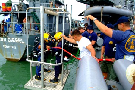 US Navy 050808-N-4772B-038 A pair of Royal Brunei Navy (RBN) divers are lowered from the rescue and salvage ship USS Safeguard (ARS 50) during familiarization dives photo