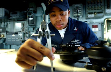 US Navy 050809-F-4883S-055 Quartermaster 3rd Class Michael Harrison plots a course in the pilot house of the guided missile cruiser USS Thomas S. Gates (CG 51) as the ship makes its way out to sea to begin PANAMAX exercises