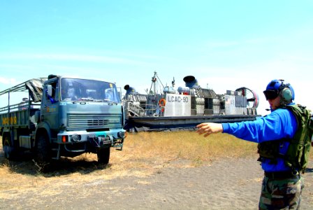 US Navy 050727-N-4772B-129 A Sailor assigned to the Beach Master Unit (BMU) Western Pacific directs an Indonesian Marine vehicle off a landing craft air cushion (LCAC) from the amphibious dock landing ship USS Harpers Ferry (LS