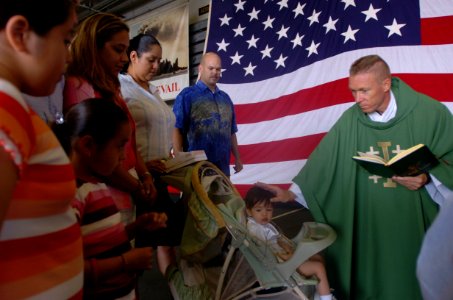 US Navy 050731-N-9866B-029 USS Peleliu (LHA 5) Chaplain, Lt. Cmdr. Keith Shuley, performs a baptism ceremony for the son of Aviation Electrician's Mate 1st Class Rob Yearicks aboard the ship