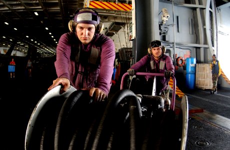 US Navy 050715-N-0413R-015 Airman Richard Vananne and Aviation Boatswain's Mate 3rd Class Max Melgar prepare to swap-out a de-fuel cart in the hangar bay aboard the nuclear-powered aircraft carrier USS Nimitz (CVN 68)