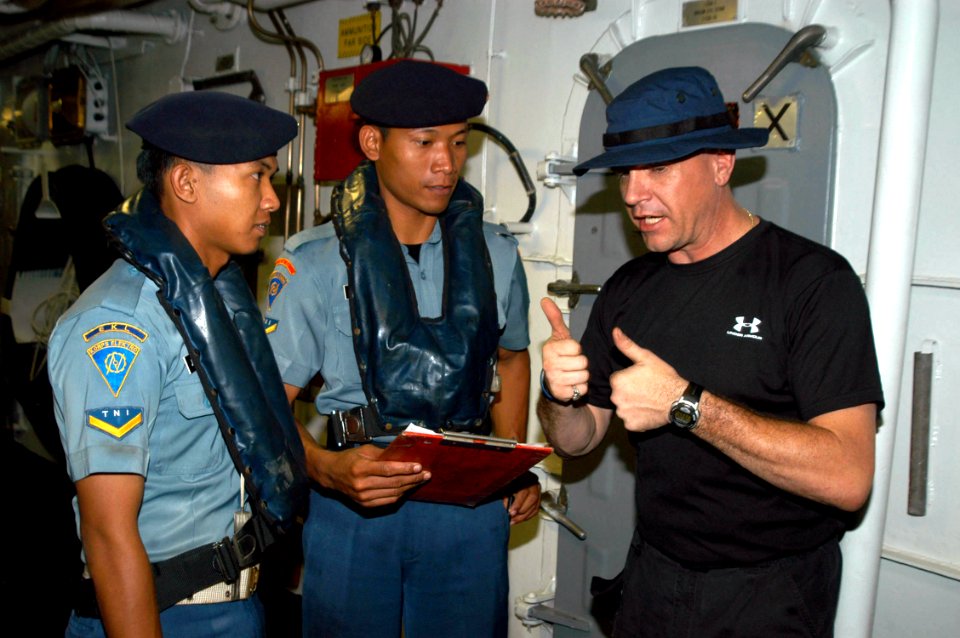 US Navy 050728-N-4104L-026 Hull Technician 1st Class William Castle, a visit, board, search and seizure (VBSS) team member aboard the guided missile frigate USS Rodney M. Davis (FFG 60) talks about his team's procedures with an