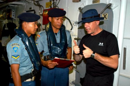 US Navy 050728-N-4104L-026 Hull Technician 1st Class William Castle, a visit, board, search and seizure (VBSS) team member aboard the guided missile frigate USS Rodney M. Davis (FFG 60) talks about his team's procedures with an
