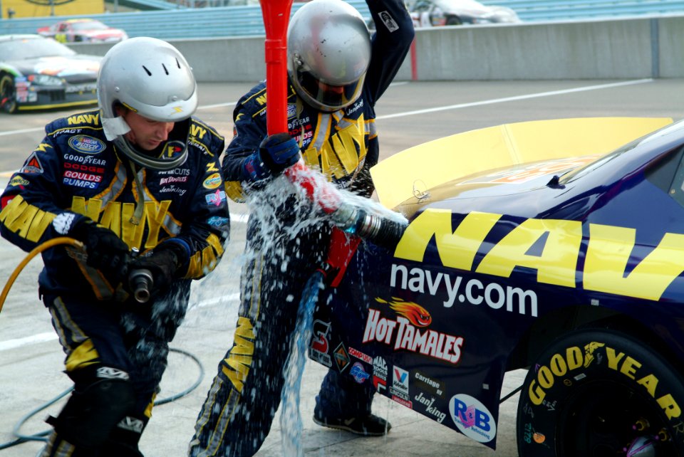 US Navy 050813-N-0962S-262 Fuel spills from the gas tank as pit crew members rush to get the No. 14 Navy Accelerate Your Life Dodge Charger back on the track