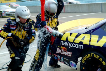 US Navy 050813-N-0962S-262 Fuel spills from the gas tank as pit crew members rush to get the No. 14 Navy Accelerate Your Life Dodge Charger back on the track