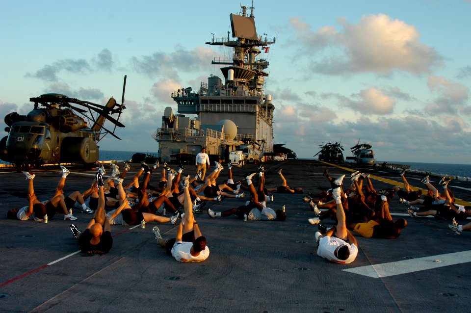 US Navy 050802-N-1134F-002 Chief petty officer (CPO) selectees stretch prior to conducting the physical readiness test at sunrise with the Chief Petty Officer's Mess aboard the amphibious assault ship USS Bataan (LHD 5)