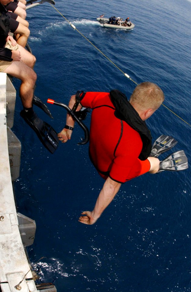 US Navy 050826-N-0413R-061 A search and rescue swimmer jumps off of a deck edge elevator during a swim call held aboard the nuclear-powered aircraft carrier USS Nimitz (CVN 68)