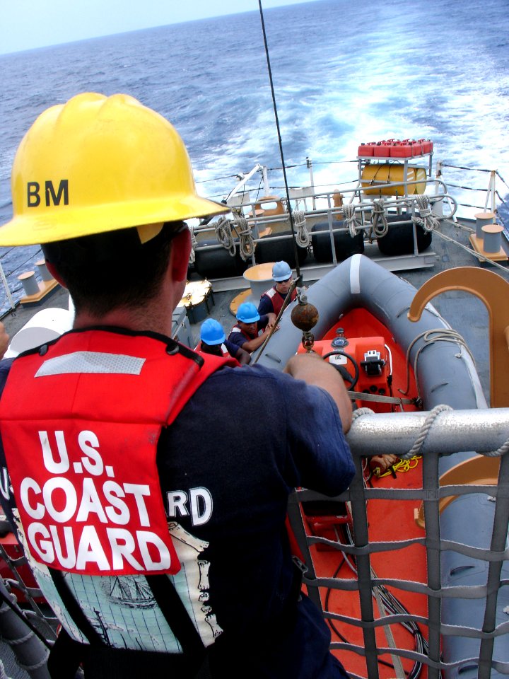US Navy 050811-N-1464F-001 U.S. Coast Guard Boatswain's Mate 3rd Class Jonathan Belval, serves as a safety supervisor as Sailors hoist-up a Rigid Hull Inflatable Boat aboard the U.S. Coast Guard cutter USCGC Forward (WMEC 911)
