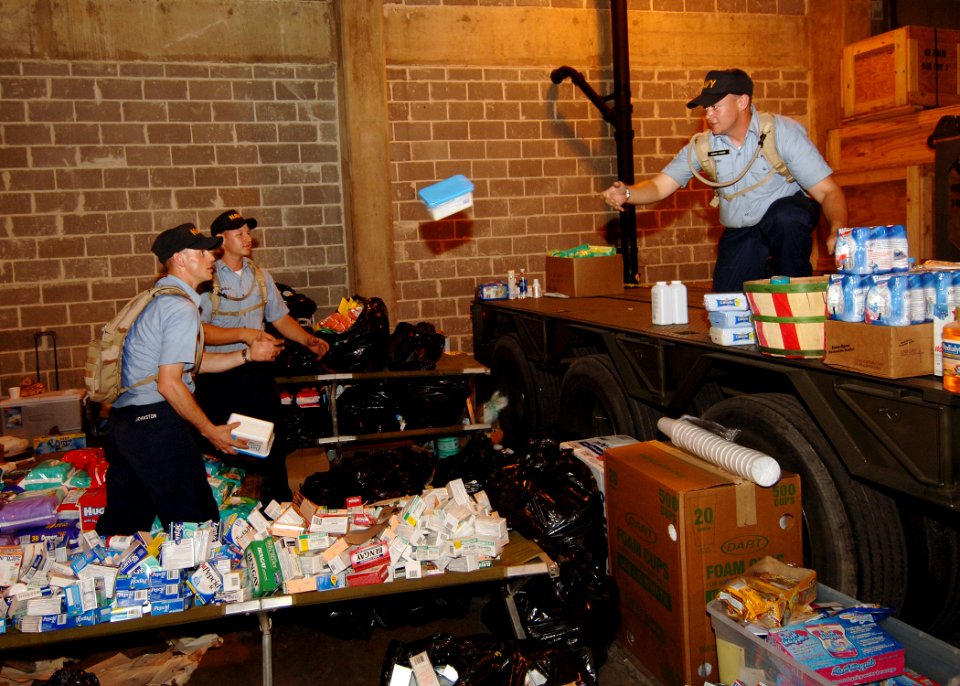 US Navy 050903-N-4374S-004 Sailors assigned to Naval Construction Training Center, Miss., transfer relief supplies for the victims of Hurricane Katrina in an equipment warehouse at the Naval Construction Battalion Center