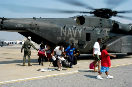 US Navy 050902-N-1467R-051 U.S. Navy air crewmen assigned to Helicopter Mine Countermeasures Squadron One Five (HM-15) stationed at Naval Air Station Corpus Christi, Texas, help hurricane victims exit an MH-53E helicopter photo