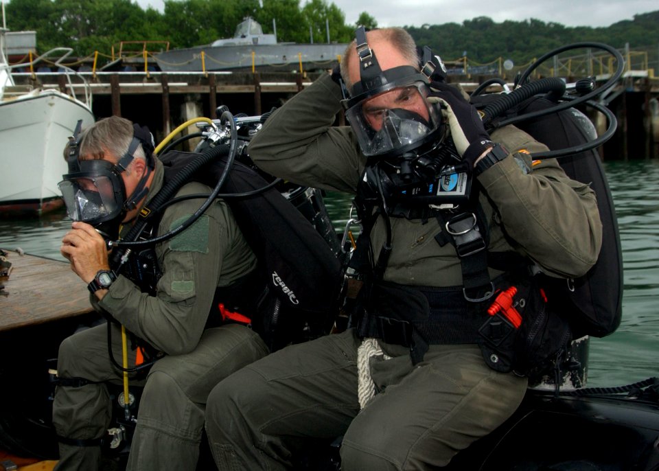 US Navy 050809-F-3177P-227 Cmdr. Mark Asselin and Electrician's Mate 1st Class Richard Van Skoik, assigned to Explosive Ordinance Disposal (EOD), prepare for a dive with their counterparts from the Panamanian National Mar
