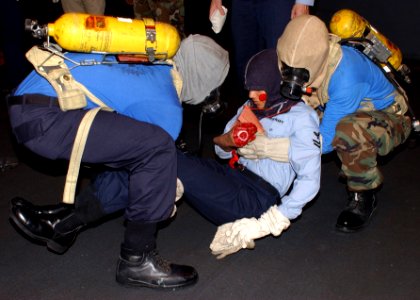 US Navy 050731-N-3891T-019 Airmen Nathanyu Grider and Sean Dixon execute a two man carry, while transporting a simulated casualty during a general quarters (GQ) drill in hangar bay two aboard the Nimitz-class aircraft carrier U