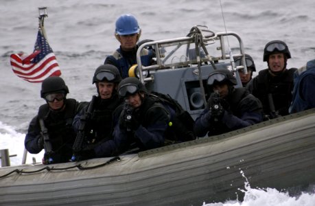 US Navy 050816-F-9085B-009 U.S. Coast Guard's Marine Safety and Security Team (MSST) stand ready with weapons drawn as they are transported in one of USS Ogden's (LPD 5) Rigid Hull Inflatable Boats