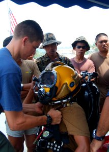 US Navy 050817-N-4772B-016 Hull Maintenance Technician 3rd Class Zachary D. Dimare, left, helps a Philippine Navy diver prepare his gear aboard the rescue and salvage ship USS Safeguard (ARS 50)