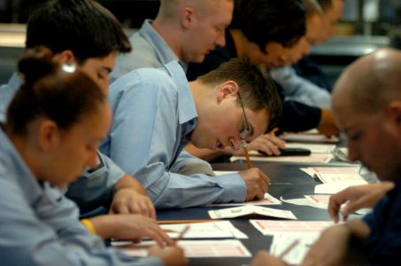 US Navy 050908-N-9866B-002 Third class petty officers, assigned to the amphibious assault ship USS Peleliu (LHA 5), concentrate during their E-5 Second Class Petty Officer examination on the mess decks aboard ship photo