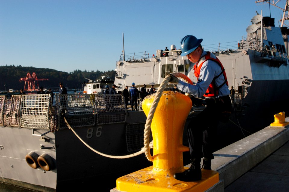 US Navy 050908-N-6477M-191 Culinary Specialist 2nd Class Sean Corcoran casts off a line from the pier as the guided missile destroyer USS Shoup (DDG 86) prepares for departure from Naval Station Everett, Wash