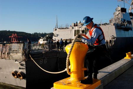 US Navy 050908-N-6477M-191 Culinary Specialist 2nd Class Sean Corcoran casts off a line from the pier as the guided missile destroyer USS Shoup (DDG 86) prepares for departure from Naval Station Everett, Wash