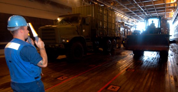 US Navy 050831-N-6204K-005 Seaman Kyle Lomax directs cargo in the well deck of the amphibious assault ship USS Iwo Jima (LHD 7)