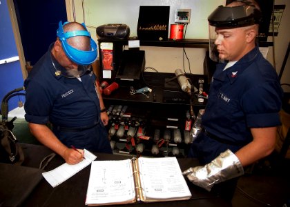 US Navy 050830-N-5134J-001 Aircrew Survival Equipmentman 1st Class, Dominic Peacock and Aircrew Survival Equipmentman 2nd Class, Paryl Blanchard, prepare to recharge a CO2 bottle