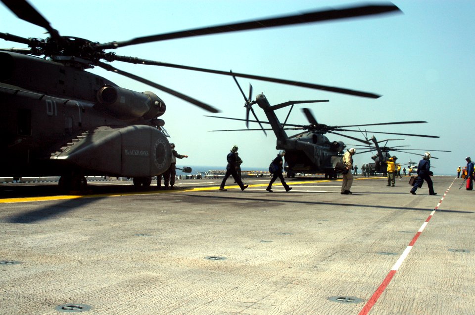 US Navy 050829-N-8154G-063 Crew members prepare to unload personnel and equipment from MH-53E Sea Dragon helicopters on board the amphibious assault ship USS Bataan (LHD 5)