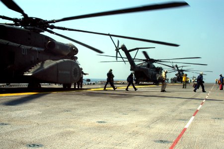US Navy 050829-N-8154G-063 Crew members prepare to unload personnel and equipment from MH-53E Sea Dragon helicopters on board the amphibious assault ship USS Bataan (LHD 5)