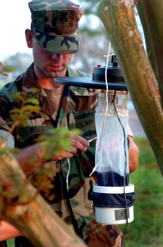US Navy 050909-N-2653P-003 Forward Deployable Preventive Medicine Unit (FDPMU) East, removes a Light Trap provided by the Centers for Disease Control (CDC) from a tent city area on board NAS JRB New Orleans