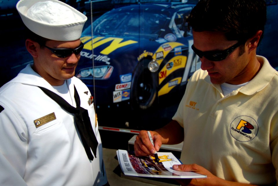 US Navy 050909-N-9769P-165 Aviation Boatswains Mate 2nd Class Elias Rodriguez receives an autograph from the No.14 Navy Dodge Charger NASCAR driver David Stremme