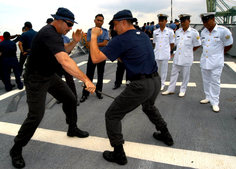 US Navy 050808-N-4104L-063 Assistant Boarding Officer, USS Rodney M. Davis (FFG 60), Chief Gunner's Mate Ross McDonell, left, uses a baton to demonstrate a non-lethal boarding techniques