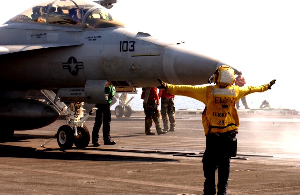 US Navy 050910-N-1416P-027 Aviation Boatswain's Mate Airman Danielle Maniscalo directs an F-A-18F Super Hornet on the flight deck aboard the nuclear-powered aircraft carrier USS Nimitz (CVN 68)
