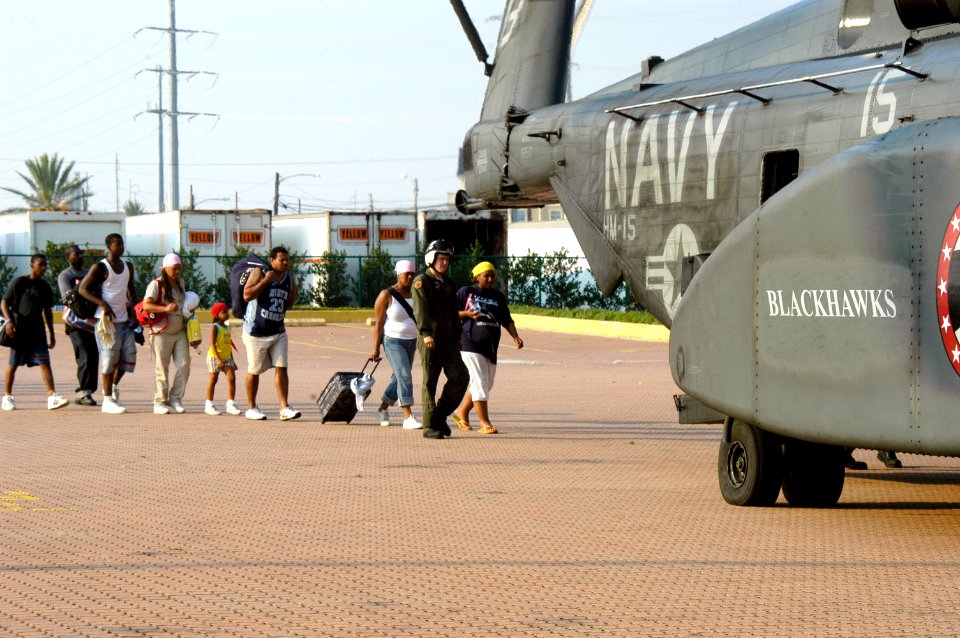 US Navy 050903-N-1467R-005 U.S Navy Aviation Machinist's Mate 2nd Class Kirk Crabb directs Hurricane Katrina survivors into the back ramp of an MH-53E Sea Dragon helicopter