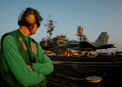 US Navy 050810-N-3488C-021 Photographer's Mate 3rd Class Adam Cobb, watches a F-A-18F Super Hornet assigned to Strike Fighter Squadron One Zero Two (VFA-102), land