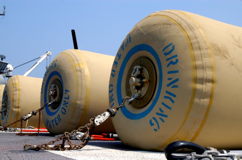 US Navy 050903-N-8154G-249 Eight rubber bladders, each holding 500 gallons of fresh drinking water, wait for transport on the flight deck of the amphibious assault ship USS Bataan (LHD 5)